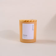 Amber glass soy wax candle with wood lid and 'eternal amaraa' label on beige background